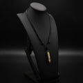 Bullet mini knife necklace by Pocket & Bear Collective on a black display bust, the brass bullet pendant closed on its adjustable black cord