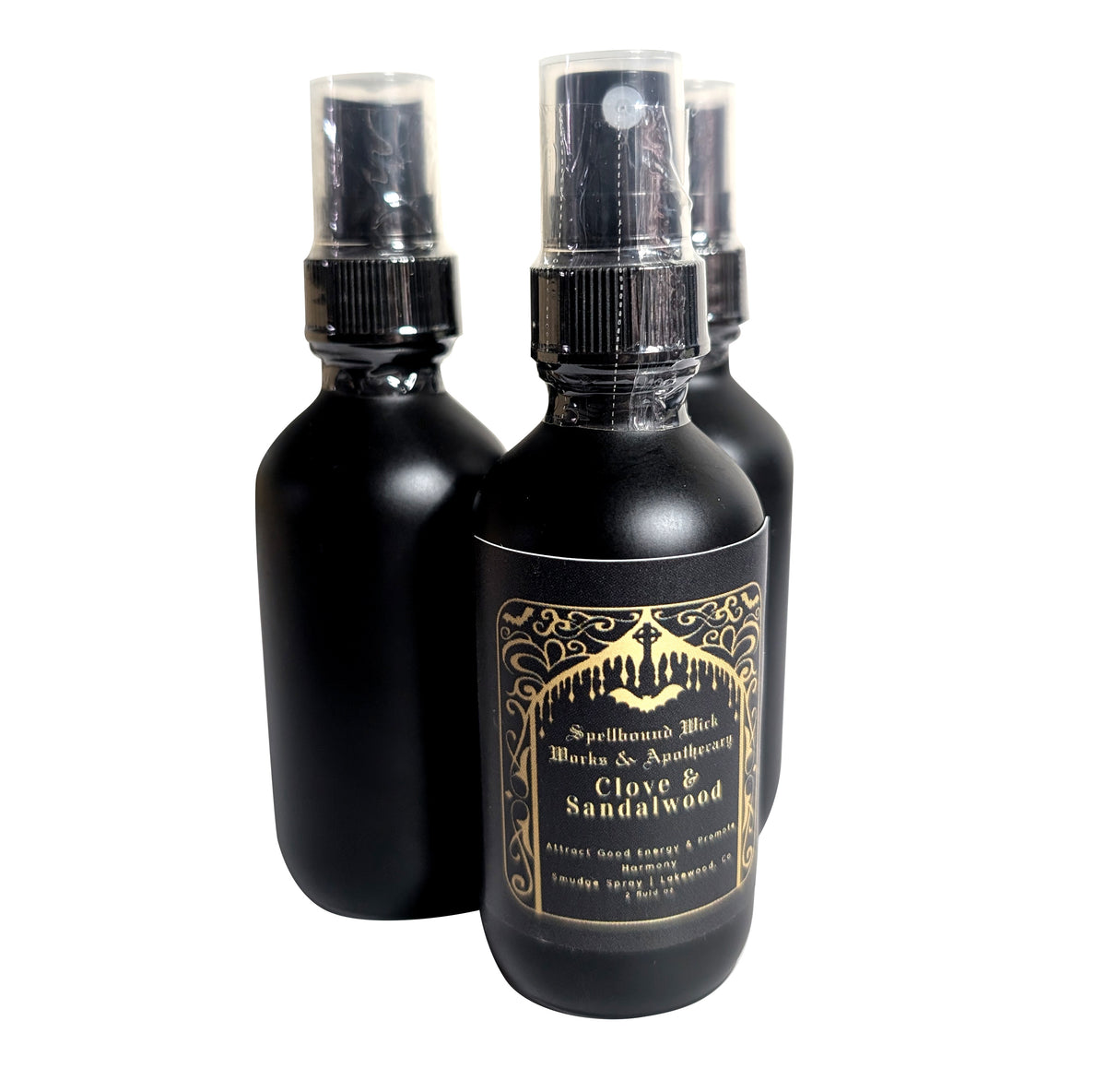 Three matte black spray bottles with clear spray tops standing together on a white background.