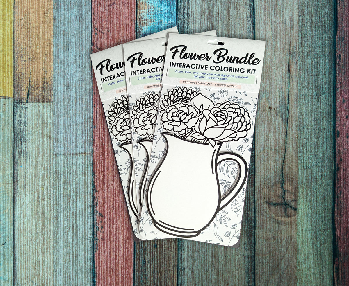 Three Flower Bundle interactive coloring kits arranged on painted wood, each in its packaging with the uncolored roses and pitcher cutouts visible.
