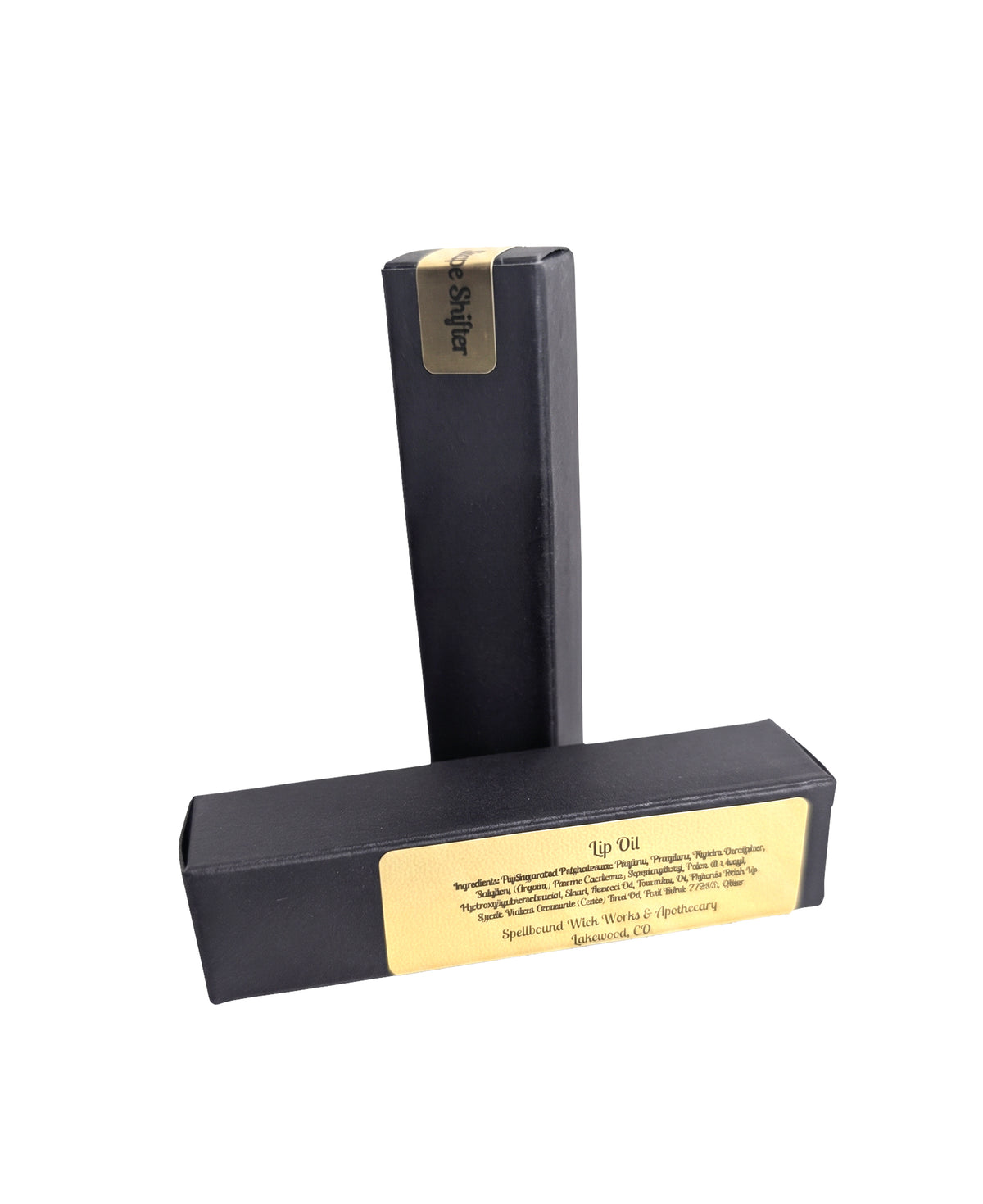 Closed black lip oil bottle beside its black box on a white background, gold label facing forward.