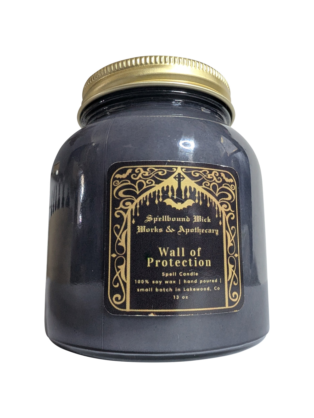 Single closed black jar candle standing upright on a white background, gold lid and gold label.
