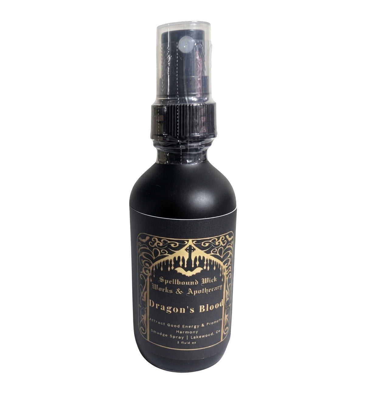 Single matte black spray bottle standing upright on marble with the gold label centered.