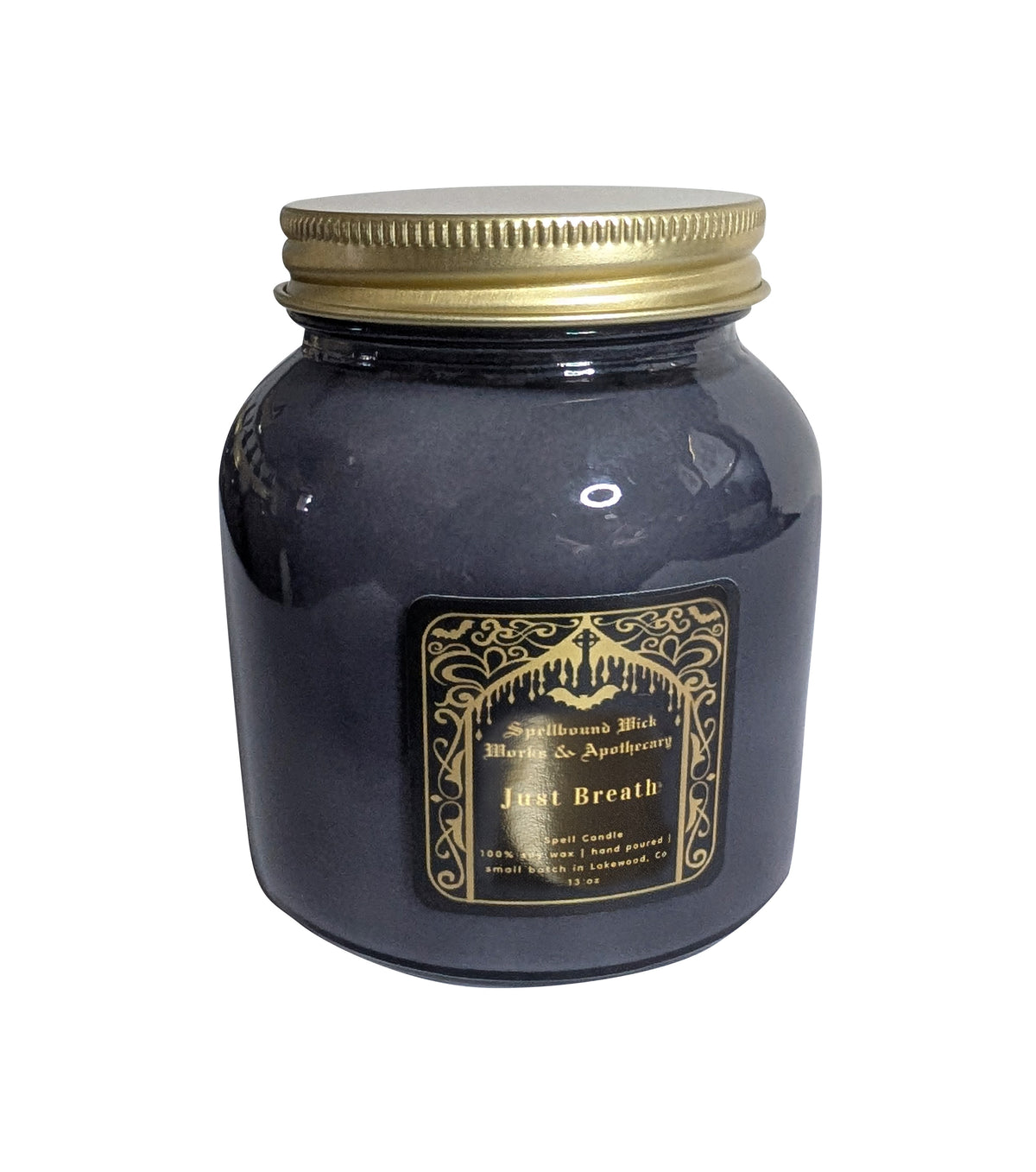 Dark gray Just Breath spell candle in a glass jar with a gold lid and black and gold label, front view on a white background