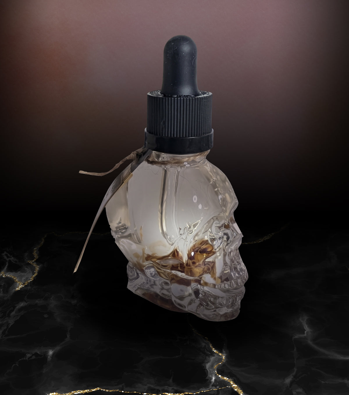 Side view of the clear skull shaped bottle of Maiden body oil staged on dark marble.