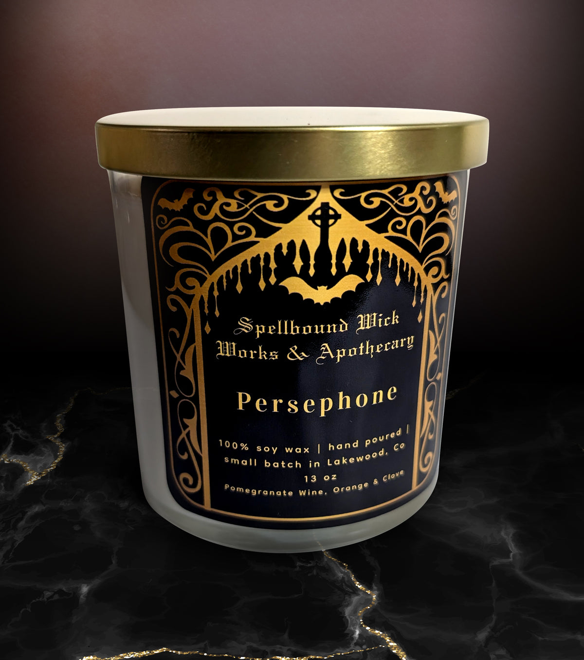 The Persephone Goddess Candle with the gold lid on, shot on dark marble