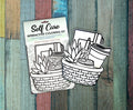 Two Self Care interactive coloring kits in their packaging on a painted wood background, showing the uncolored basket and self care cutouts behind the Self Care header card.