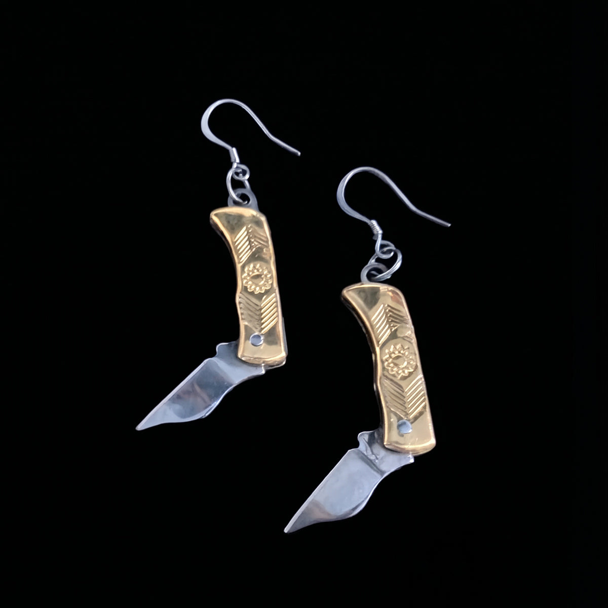 Brass flower mini pocket knife earrings by Pocket & Bear Collective with the stainless steel blades swung open, on a black background