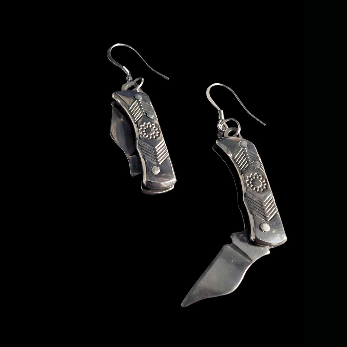Silver flower mini pocket knife earrings by Pocket & Bear Collective on a black background, one stainless steel blade swung open