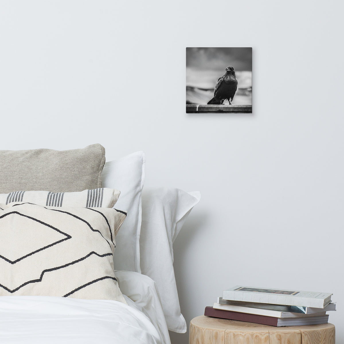 Crow So Chic canvas print by Iain Camacho, small canvas hanging above a bed with white and patterned pillows