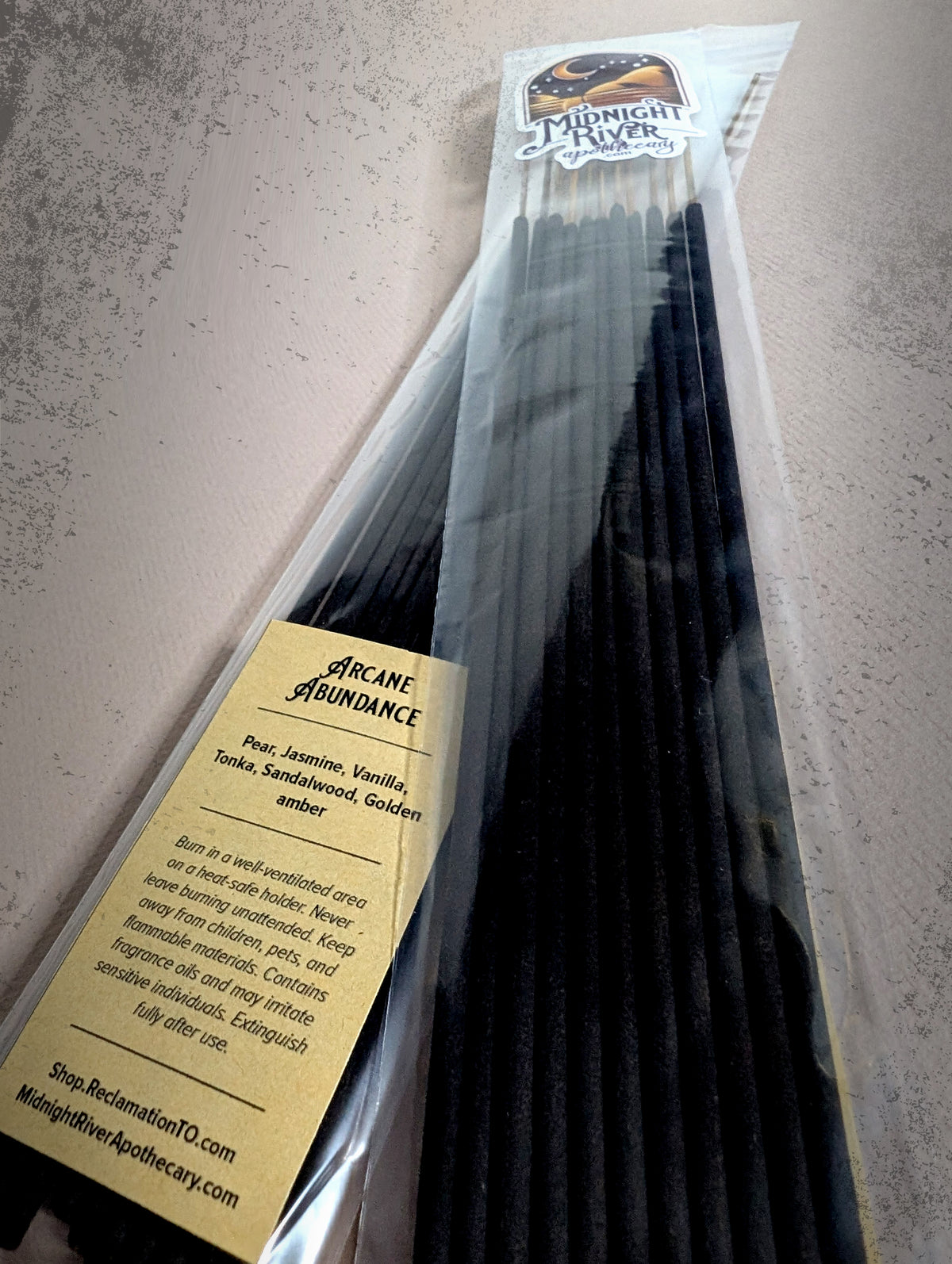 Second angled view of the bagged black incense sticks on dark slate, showing the label and the tops of the sticks