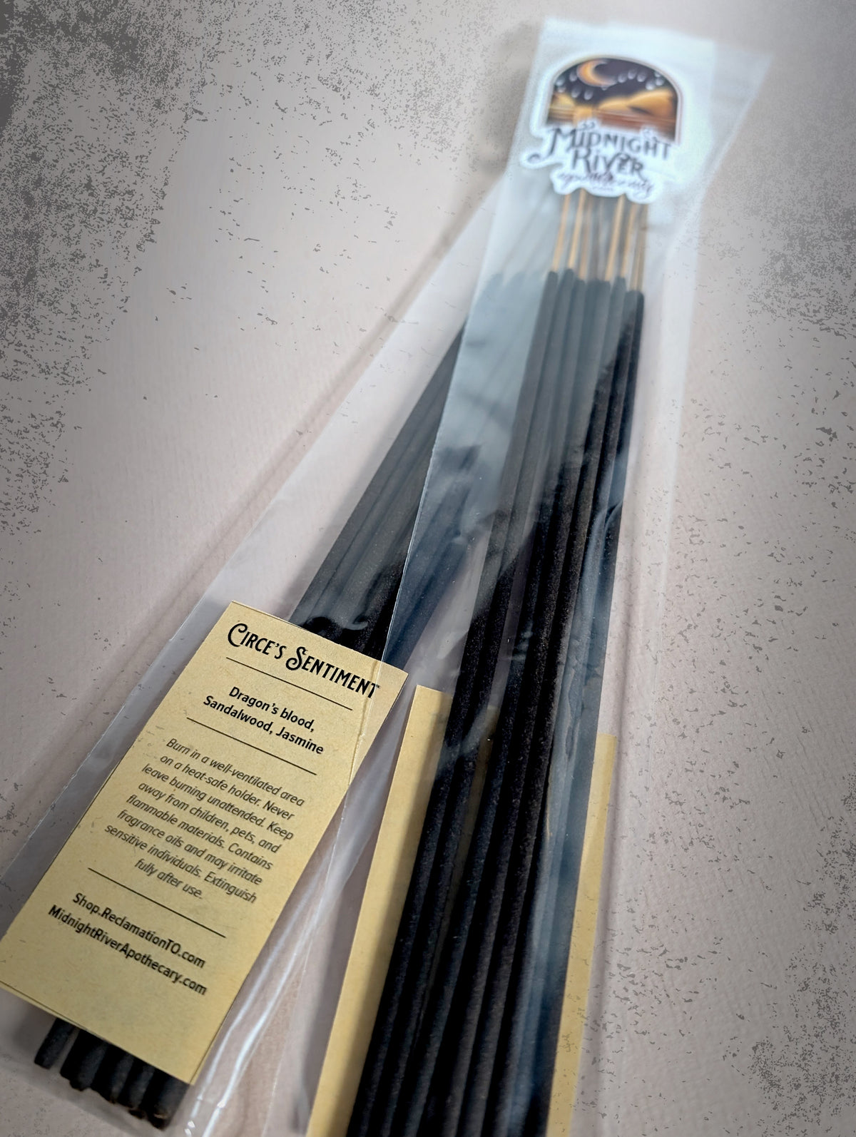 View of the bagged incense on a light gray surface, showing the label and the tops of the sticks