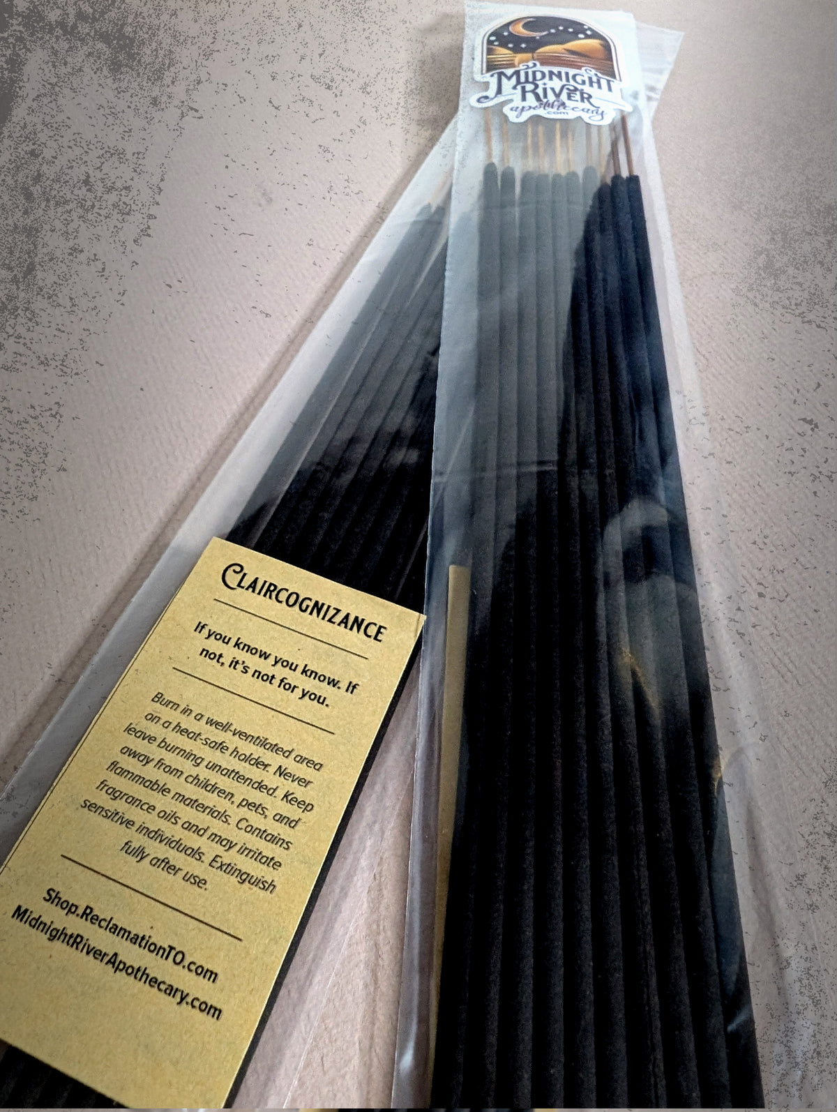 Second angle of the Claircognizance incense bag from Midnight River Apothecary, with the yellow label and the black sticks inside.
