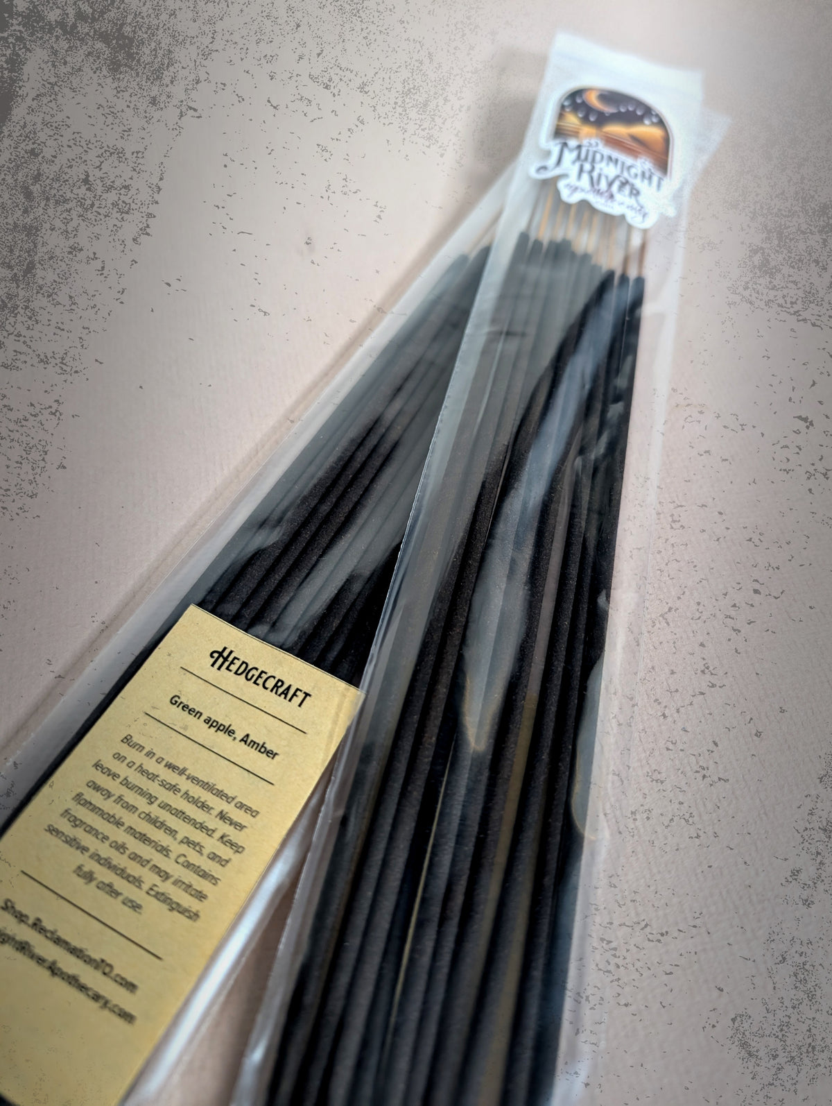Second angled view of the bagged black incense sticks on a light surface, with the label visible near the bottom