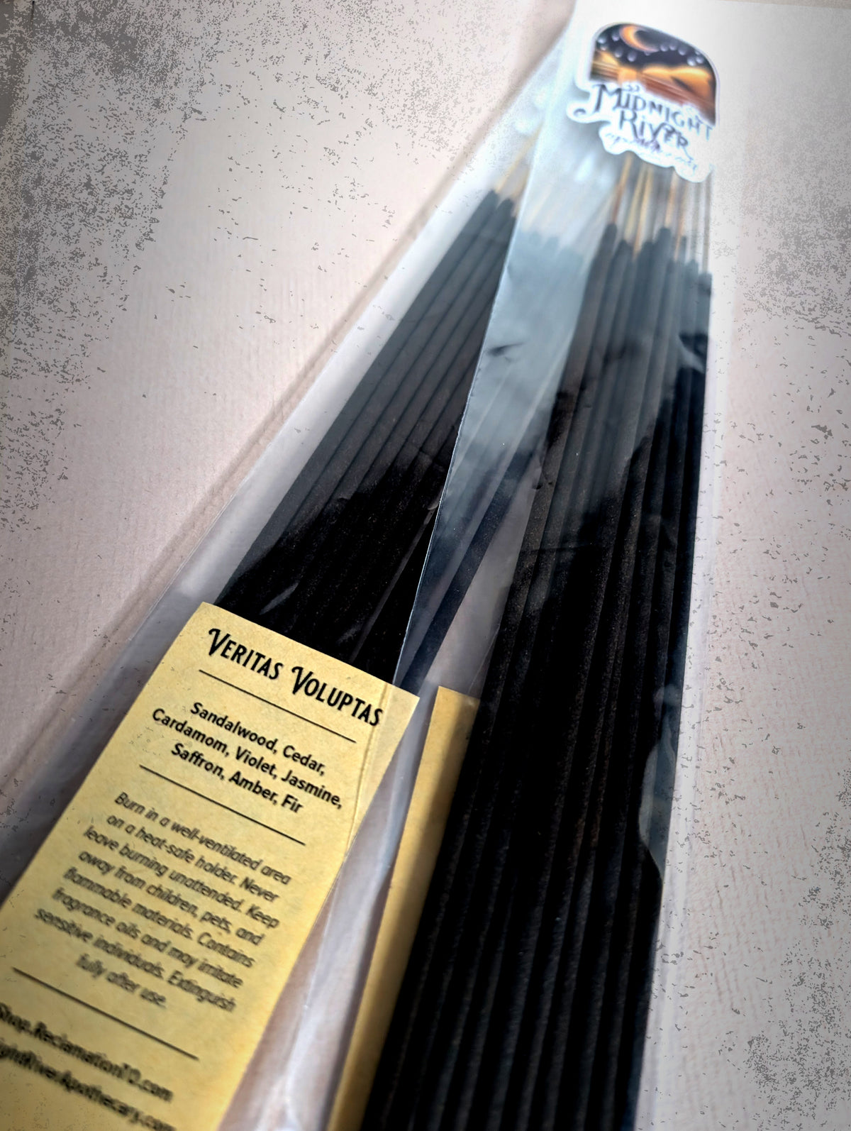 Second view of the bagged incense bundle on a light gray surface, with the label visible near the bottom