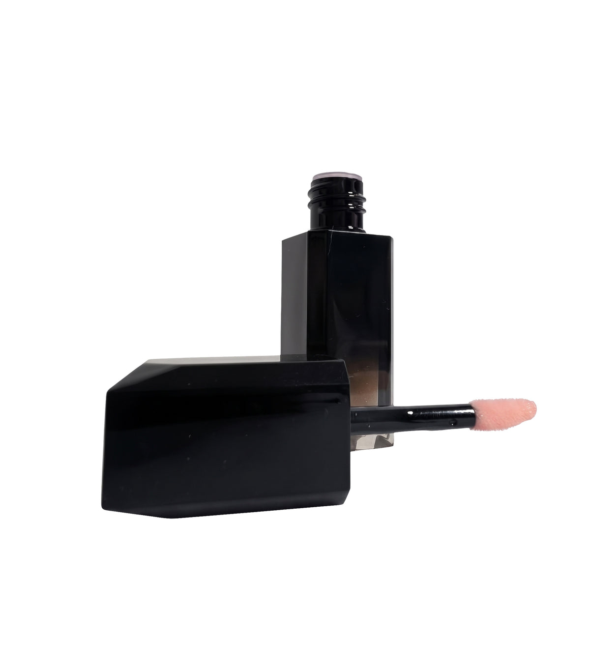 Black lip oil bottle opened on a white background, cap and wand set in front with pale pink oil on the tip.