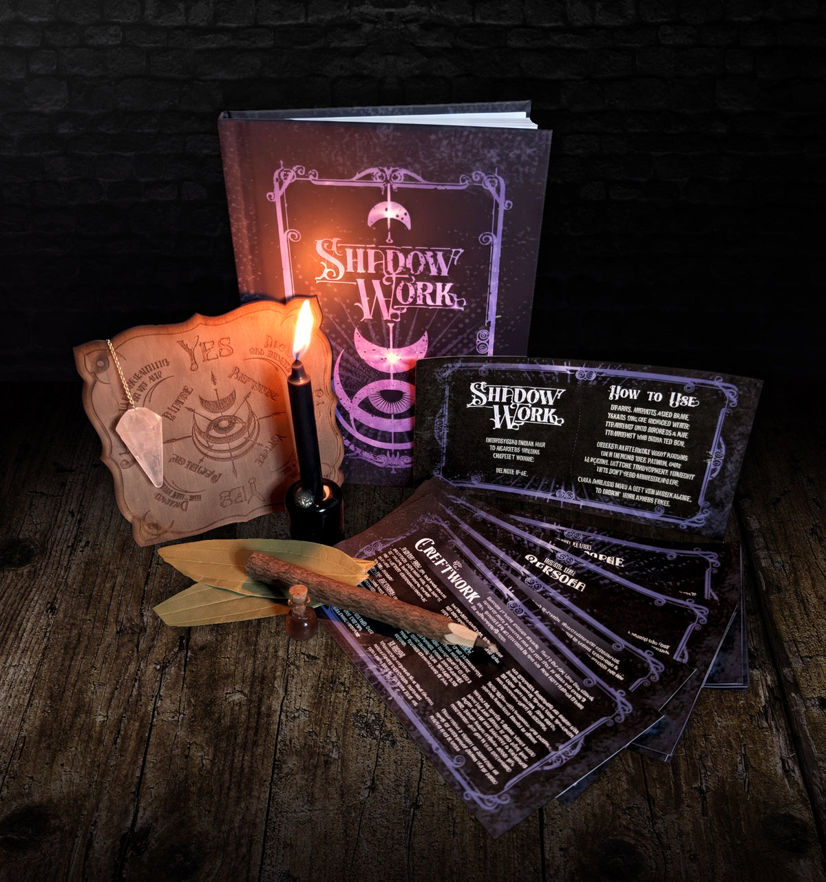 Shadow Work Ritual Kit by Midnight River Apothecary, with the hardcover journal, etched wooden pendulum board and quartz pendulum, a lit black chime candle, bay leaves, a twig pencil, a corked oil bottle and the card set fanned out on dark wood
