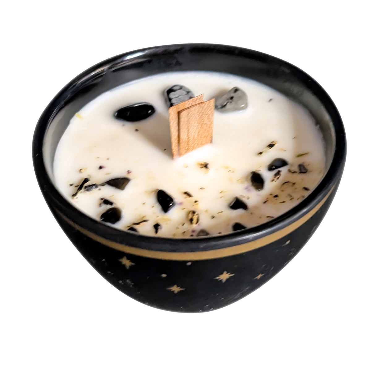 Black star candle seen from above on a white background, showing the black and snowflake obsidian pieces set into the wax surface beside the wooden wick