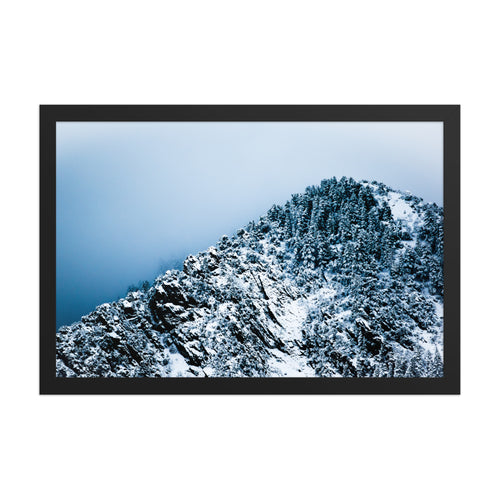 Colorado Mountain framed luster print by iain, front view of a black framed photograph of a snow covered mountain ridge with dense pine trees rising into cold blue cloud
