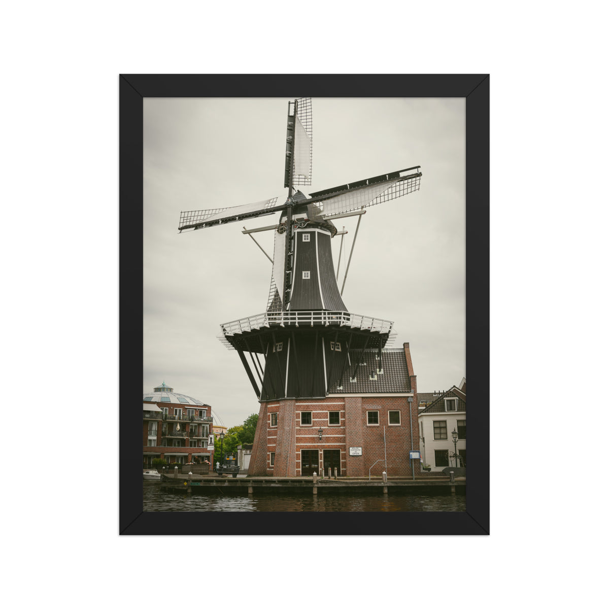 De Adriaan, Haarlem framed luster print by iain, front view of the black framed print showing the windmill and the brick buildings at its base
