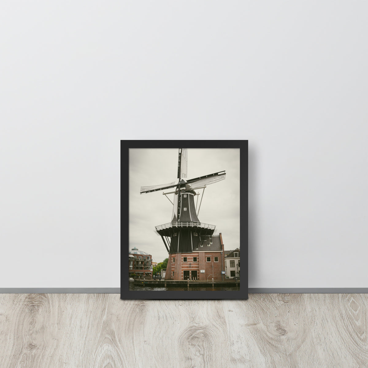 De Adriaan, Haarlem framed luster print by iain, black framed print resting on a light wood floor against a white wall