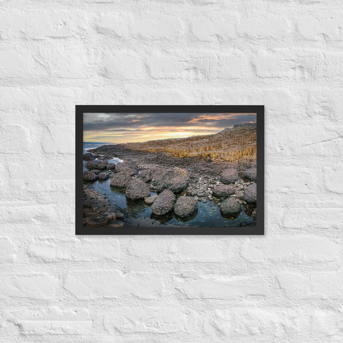 Giant's Causeway, Northern Ireland framed luster print by iain, black framed print hanging on a white brick wall