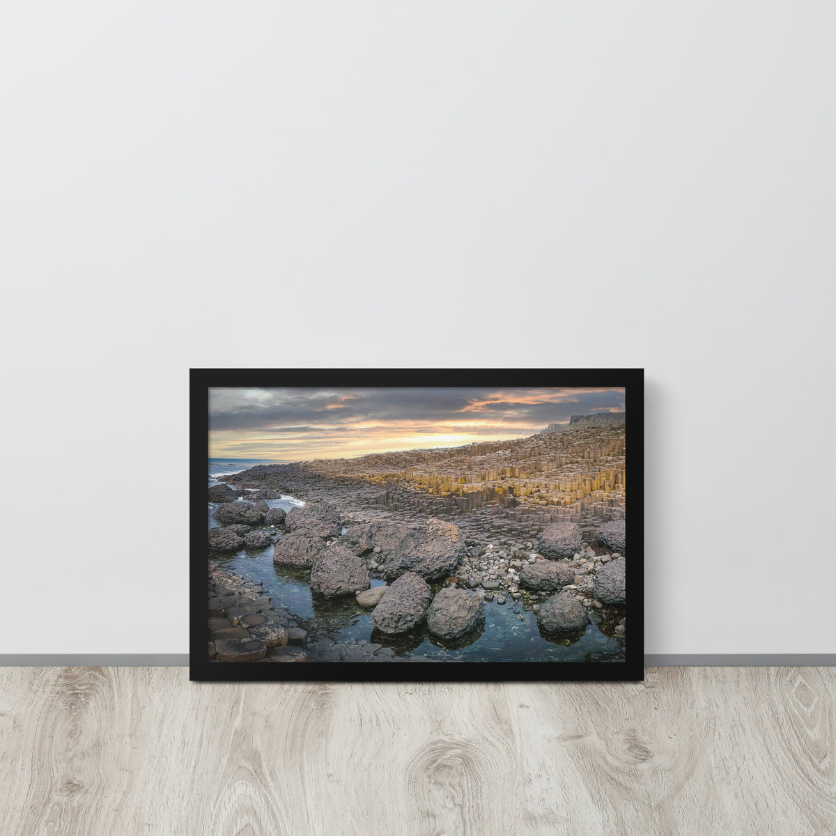 Giant's Causeway, Northern Ireland framed luster print by iain, black framed print resting on a light wood floor against a white wall