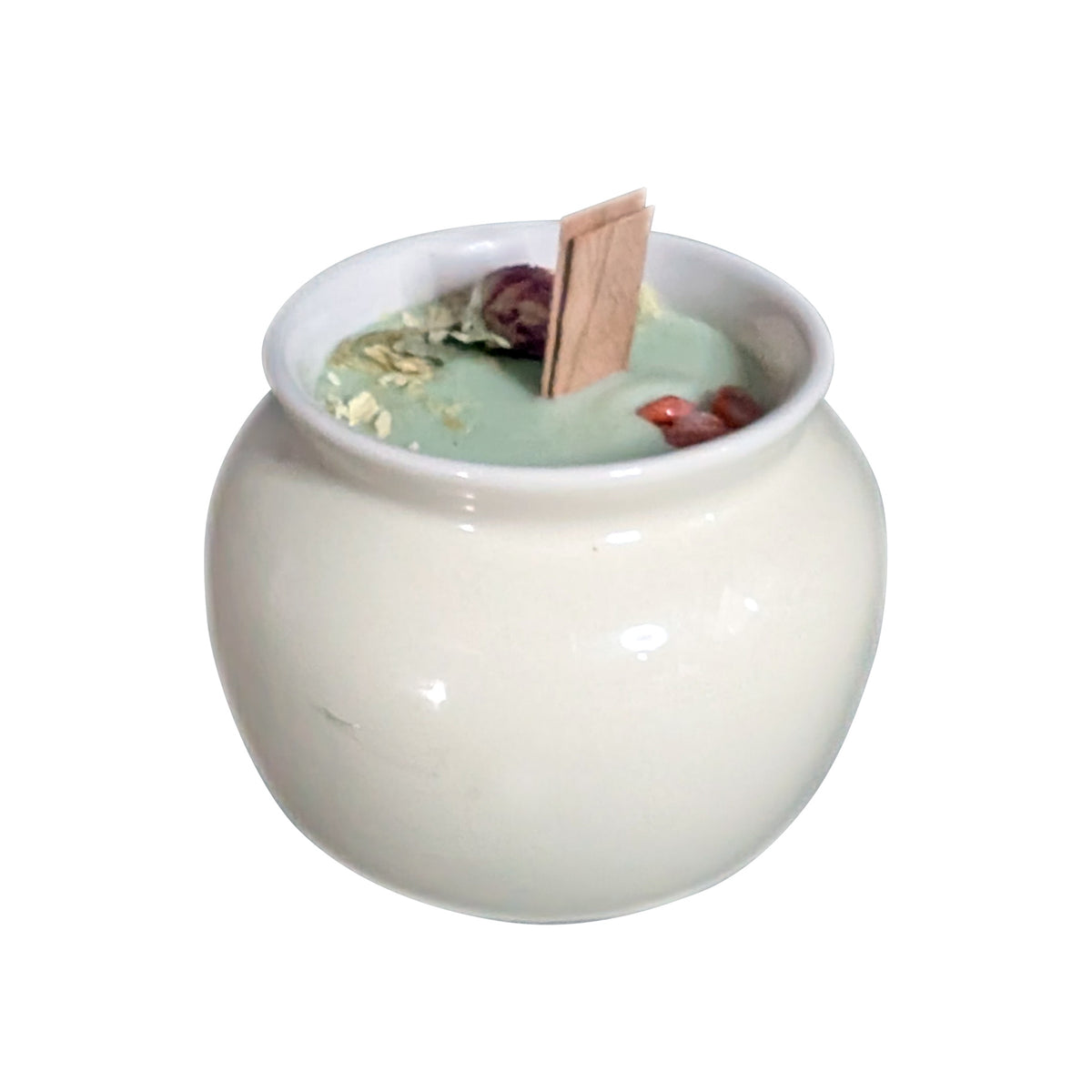 Cream porcelain pot candle on a white background, pale green soy wax topped with dried red globe amaranth and white botanicals around a flat wooden wick