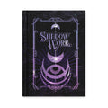 Shadow Work journal by Midnight River Apothecary, matte hardcover in black with a purple ornate frame, crescent moons, and a radiating all-seeing eye below the title