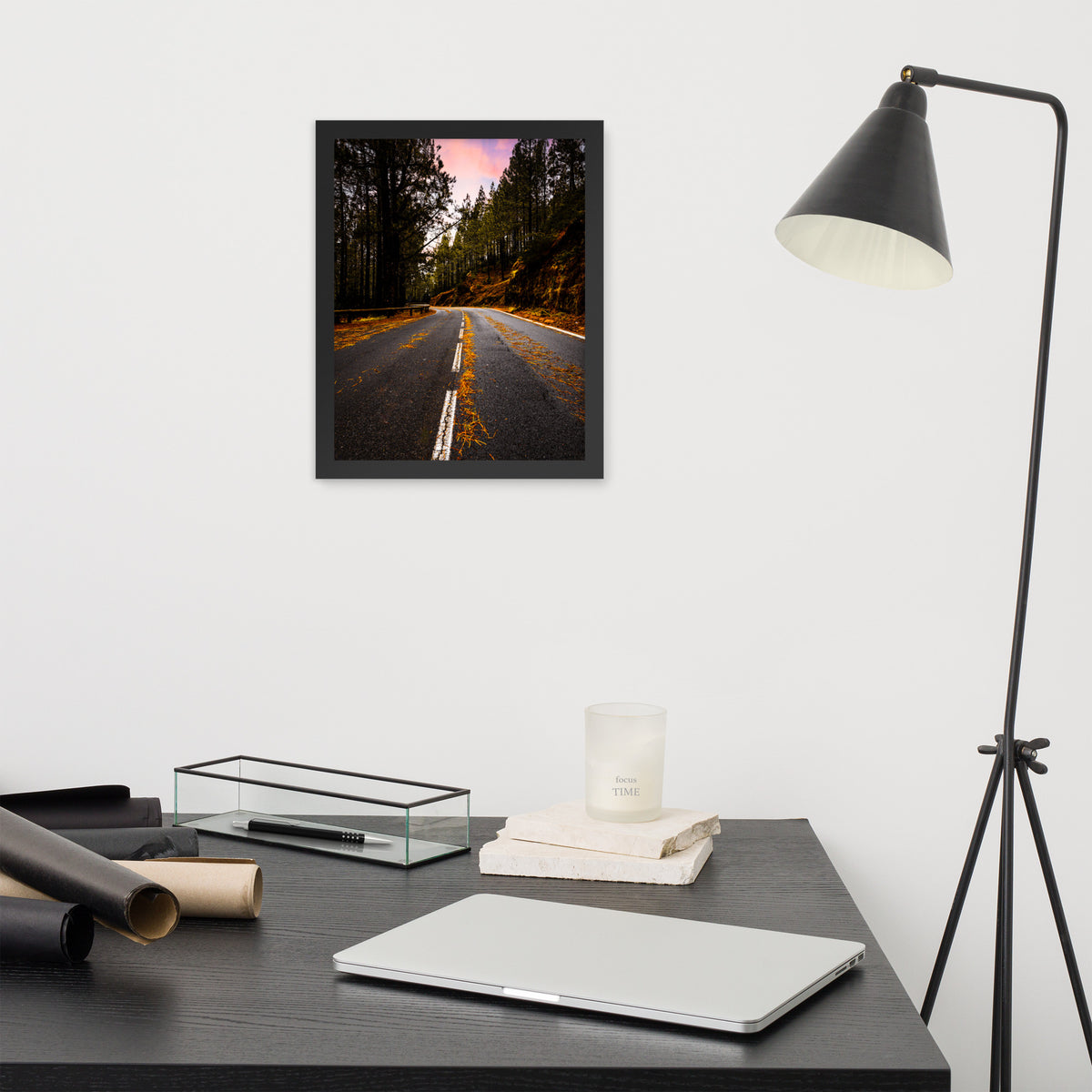 Mountain Road framed luster print by iain, smaller black framed print hanging above a desk next to a black floor lamp