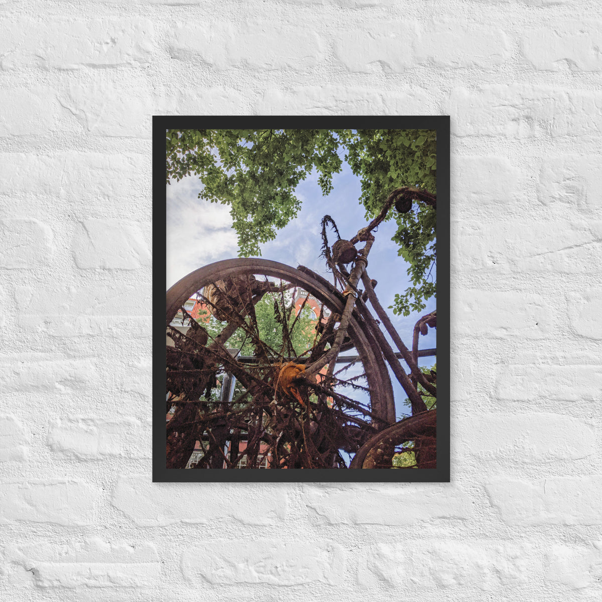 Rusty Bicycle framed luster print by iain, smaller black framed print hanging on a white brick wall