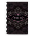 Witchy Shit spiral notebook front cover, black lace and damask in pink and grey with a bat carrying the title in gothic lettering across the center