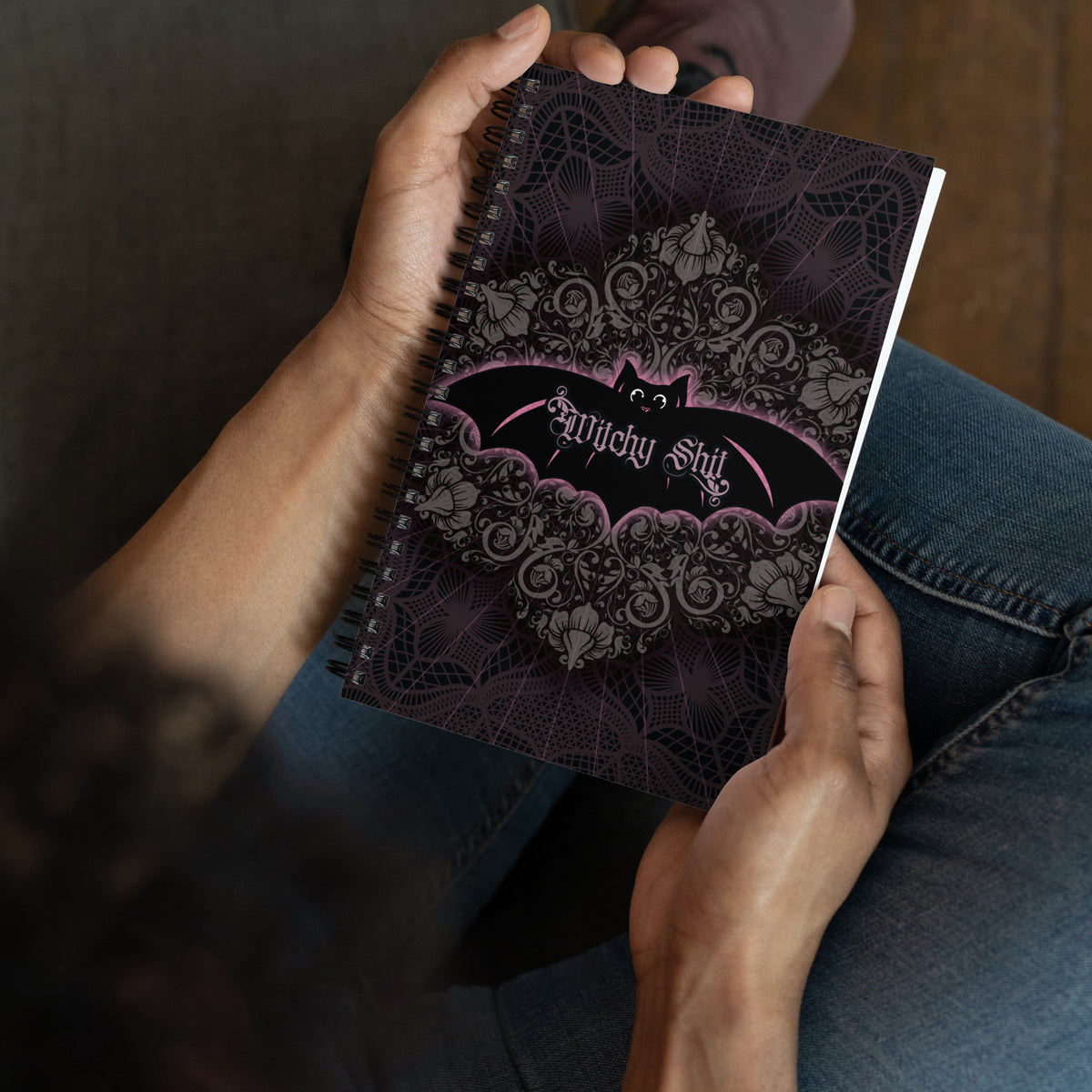 Person holding the Witchy Shit spiral notebook open in both hands