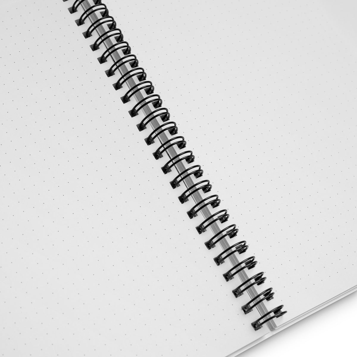Interior of the notebook open to blank dotted pages, showing the black wire-o binding down the center