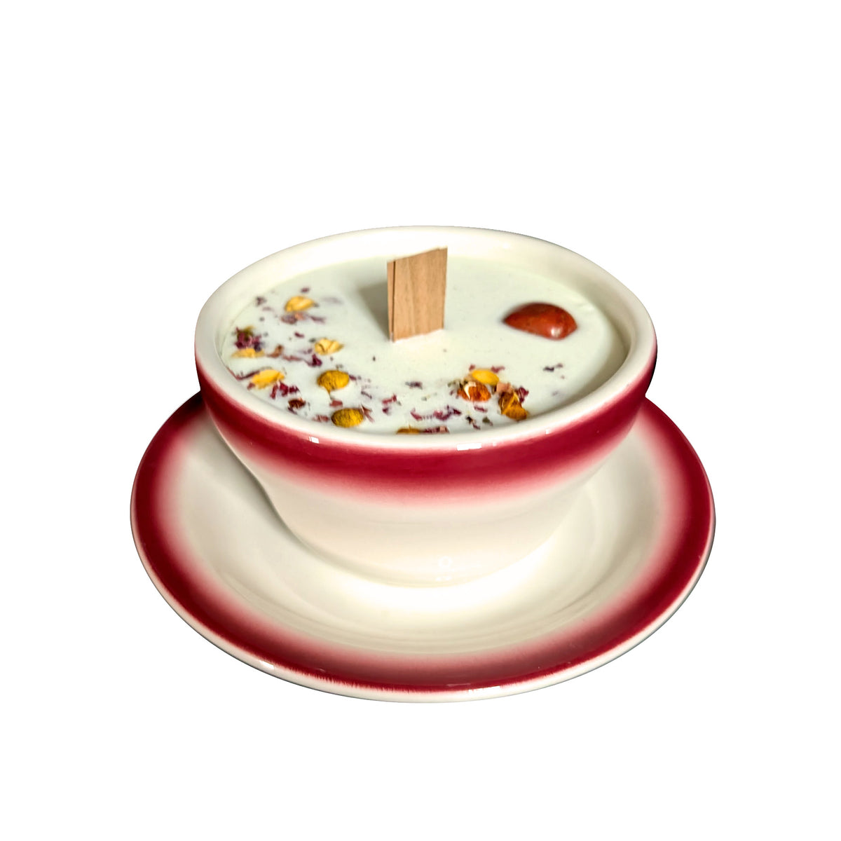 Red and white teacup candle with saucer, front view on a white background, white soy wax topped with dried botanicals and a flat wooden wick