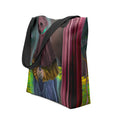 White polyester tote bag featuring an all-over surreal digital painting print of a robed figure against a vibrant vertical-striped abstract background.